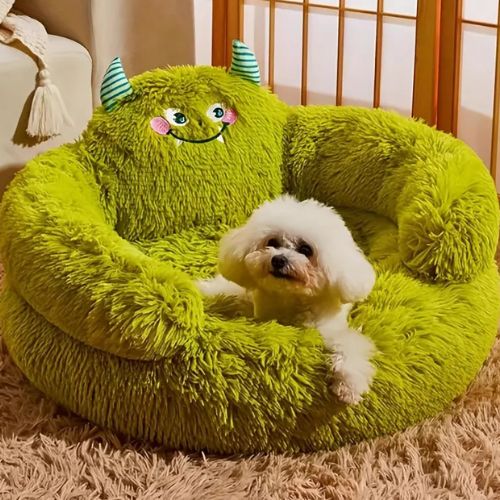 Petit chien blanc installé dans un canapé chien rond et moelleux vert