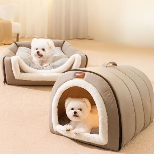 Deux petits chiens blancs installés confortablement dans une niche chien interieur grise et un lit assorti, dans une piÚce lumineuse et chaleureuse.