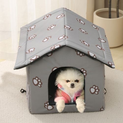 Chien assis paisiblement dans une niche pour chien et chat extérieur grise, installée dans un salon moderne, avec motifs pattes et toit protecteur.