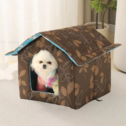 Un Caniche blanc installé dans une niche pour chien extérieur imperméable et coup vent posé sur une terrasse