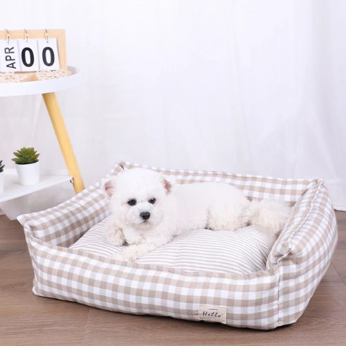 Petit chien couché dans un panier pour chien moelleux en tissu vichy beige, placé dans un intérieur lumineux
