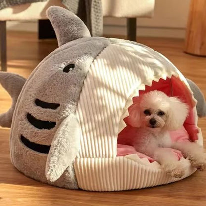 Chien assis à l’intérieur d’une niche interieur chien grise moelleuse en forme de requin, refuge douillet et décoratif.