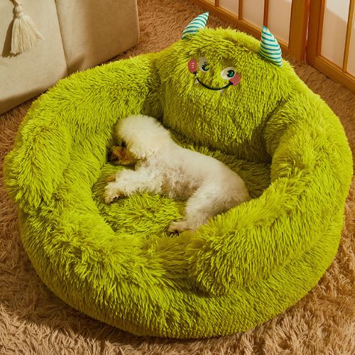 Un caniche allongé paisiblement dans canapé chien vert rond posé au sol dans un salon