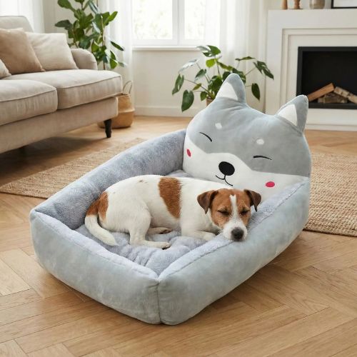 Un petit chien dort dans un canapé lit pour chien gris design original avec oreilles et visage de chat.