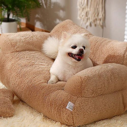 Un petit chihuahua blanc assis tranquillement sur un canapé pour chien doux et moelleux de couleur beige