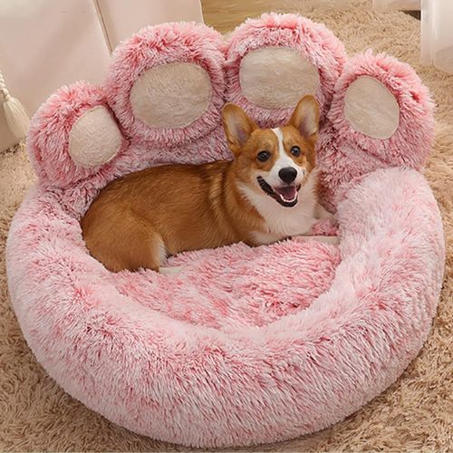 Petit chien marron installé confortablement sur un coussin pour chien format patte d'ours rose doux et moelleux