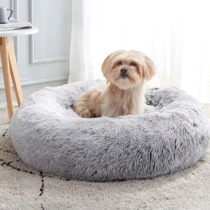Coussin pour chien cocon gris clair avec un chien relaxé posé au centre du coussin
