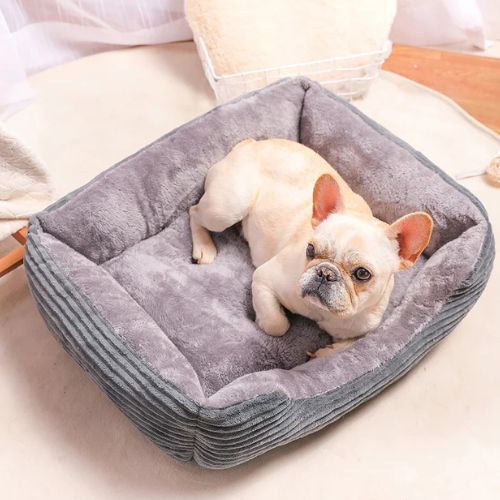 Petit bouledogue allongé confortablement dans un lit pour chien en peluche gris, offrant douceur et bien-être au quotidien.