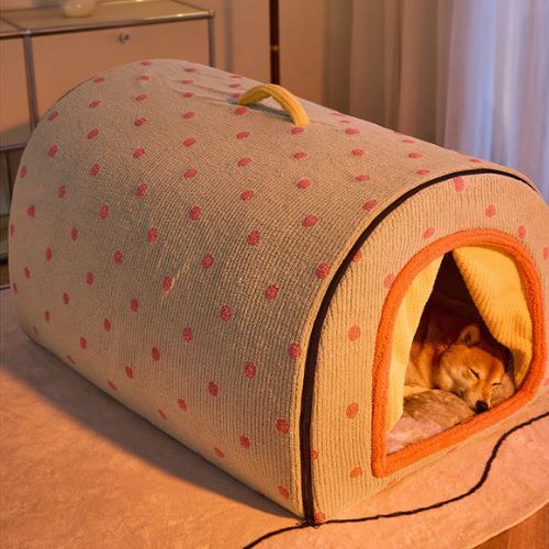 Petit chien profondément endormi dans une niche XXL pour chien à pois, au design semi-arc enveloppant et chaleureux, dans une ambiance cosy du soir.