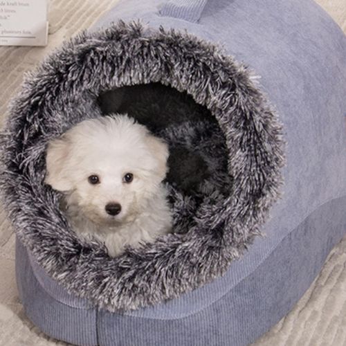 Petit chien blanc confortablement installé dans une niche pour chien en peluche douce, au design moderne et cocooning.