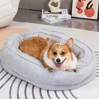 Chien Corgi détendu dans un panier orthopédique chien gris avec la mousse mémoire de forme, offrant confort et soutien articulaire.