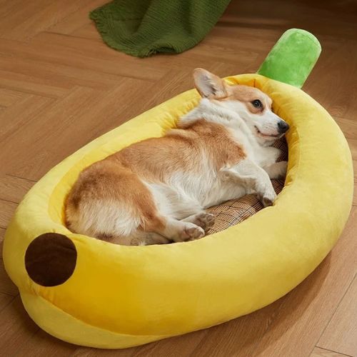 Panier pour chien XXL déhoussable en forme de banane, avec coussin moelleux et petit chien allongé confortablement.