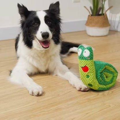 Chien heureux posant à côté de la peluche chien interactif escargot vert enroulée