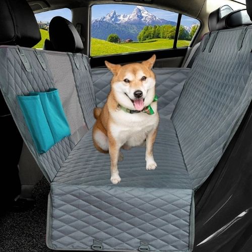 Chien assis sur une protection voiture chien gris robuste adaptée aux grands trajets