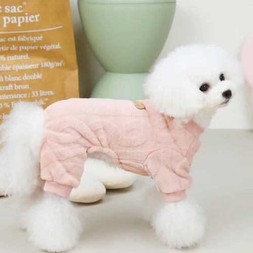 Un Caniche de profile porte un pull pour chien rose extensible facile à enfiler
