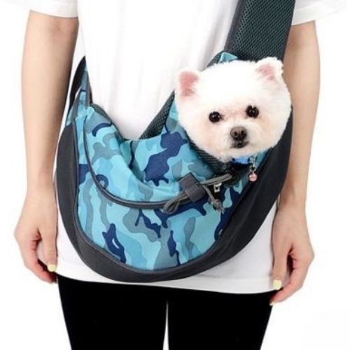un petit chien dans un sac bandoulière chien couleur bleu camouflage tendance avec poche pour téléphone,  confortable et mains libres pour promenade.