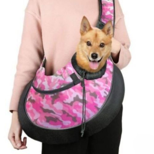 un petit chien dans un sac bandoulière chien couleur rose camouflage tendance avec poche pour téléphone,  confortable et mains libres pour promenade.