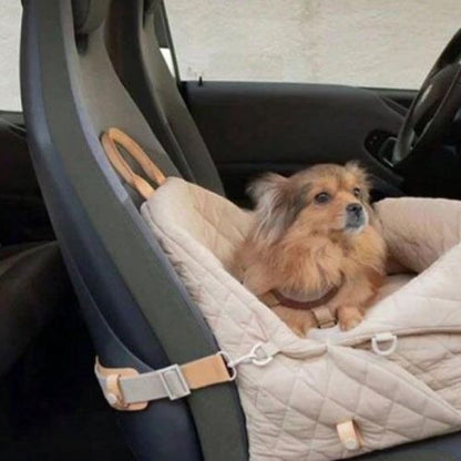 Petit chien assis confortablement dans un sac de transport pour chien rembourré marron, installé sur un siège de voiture pour un trajet en toute sécurité et avec style