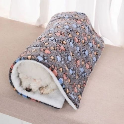Un chiot enrouler dans un tapis de chien comme une couverture épais pour les journées froide ou l'hiver